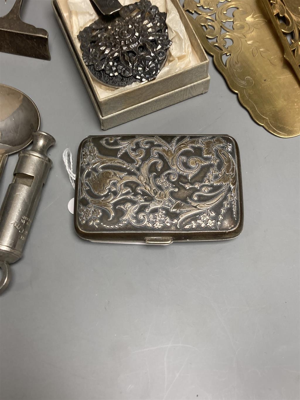 Two plated whistles, Acme and Metropolitan, a white metal embossed cigarette case and sundry items,